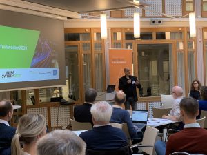 Fredrick Lekarp talar inför publik med presentation från InfraSweden2030 i bakgrunden